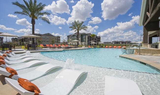 a pool with lounge chairs around it